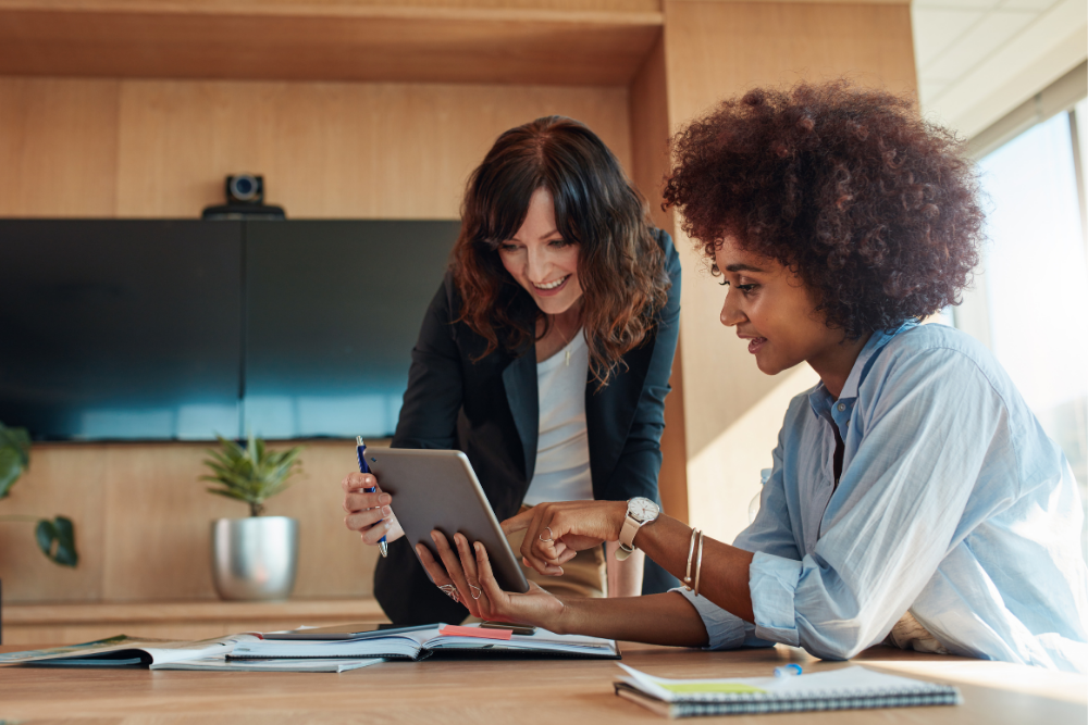 Two female employees review the Forrester report on an iPad.